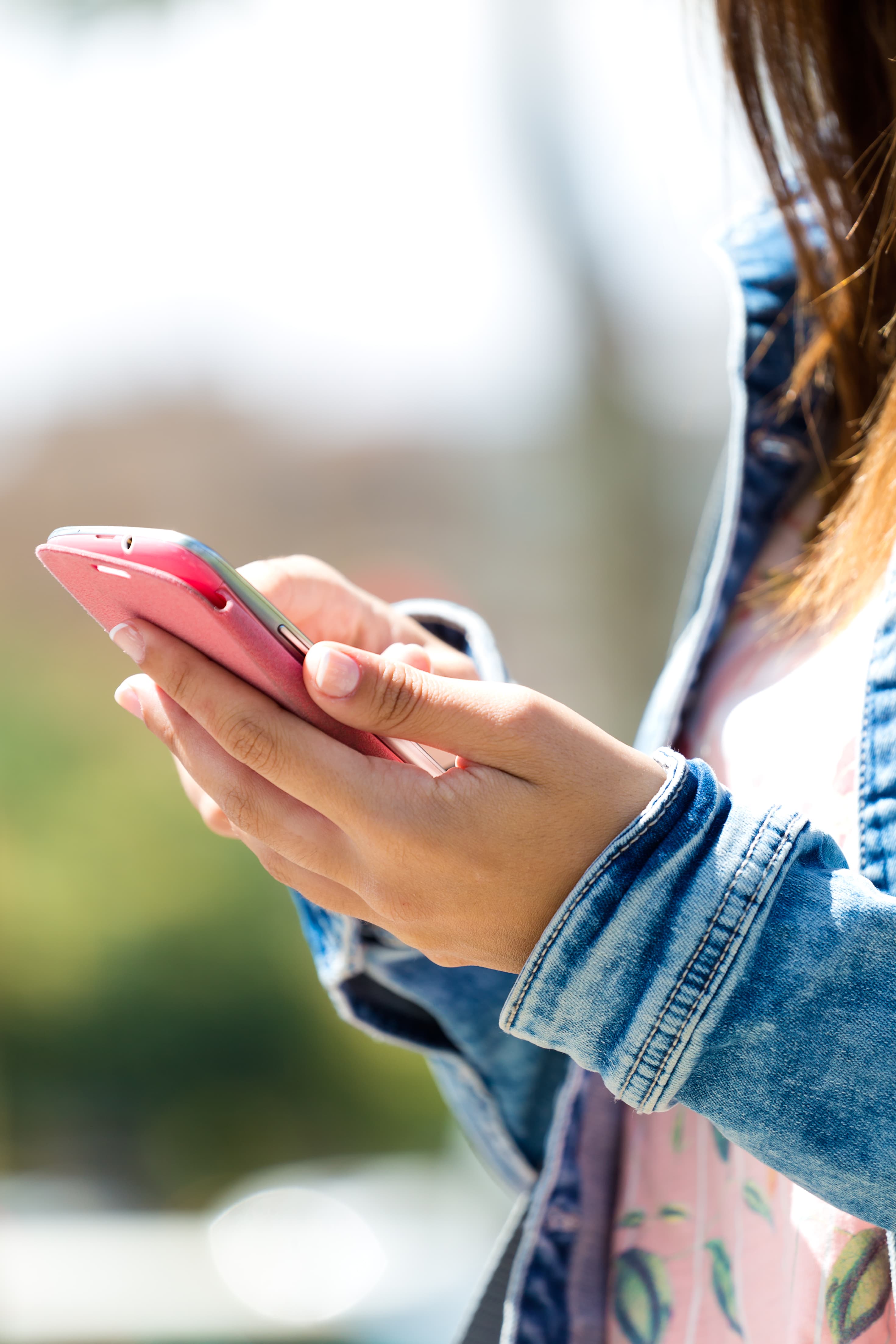 Person interacting with smartphone, representing real-time notifications and multichannel customer communication across SMS, email, push, and messaging apps.
